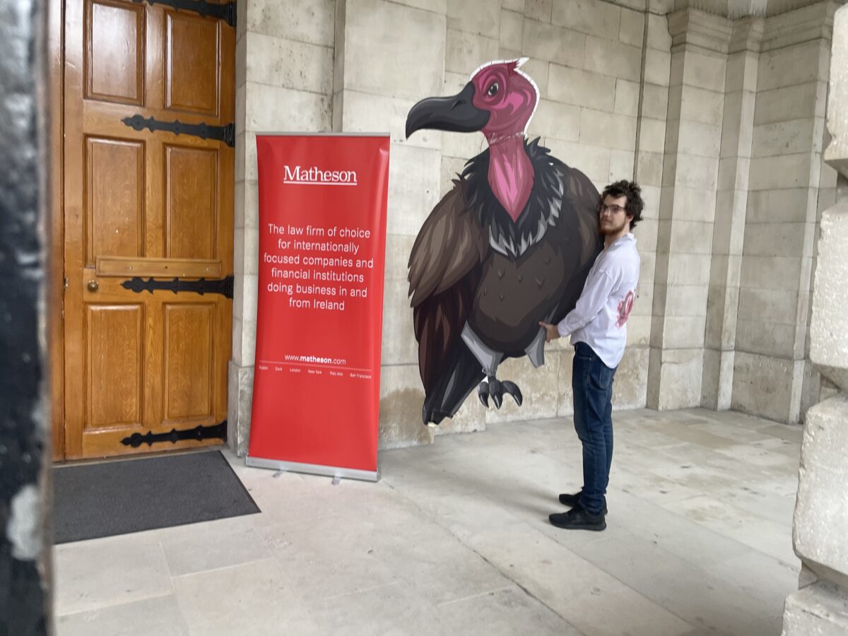 Picture of TCD student holding a large turkey cut-out in front of a Matheson poster. Image credit: TCDSU.
