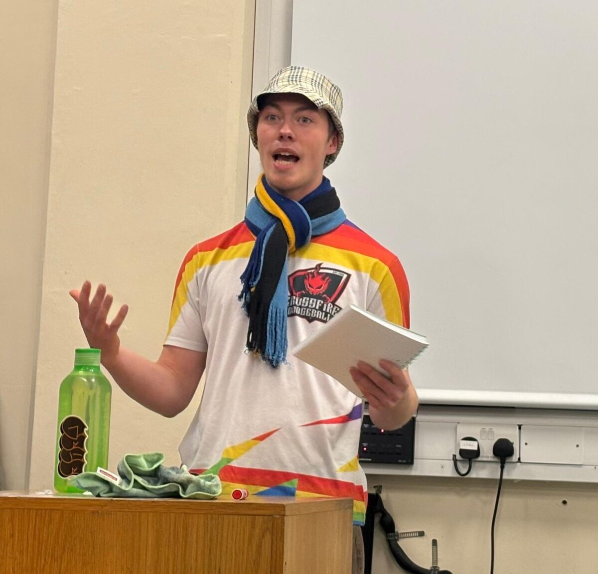 A young man speaks standing up behind a podium.