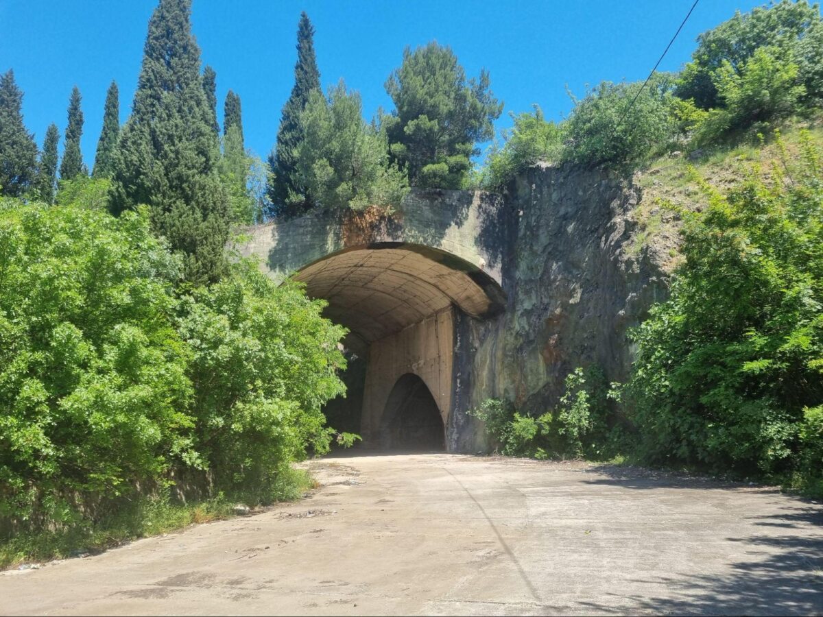 Abandoned Yugoslavian military base entrance. Tunnel entrance surrounded by trees and vegetation.